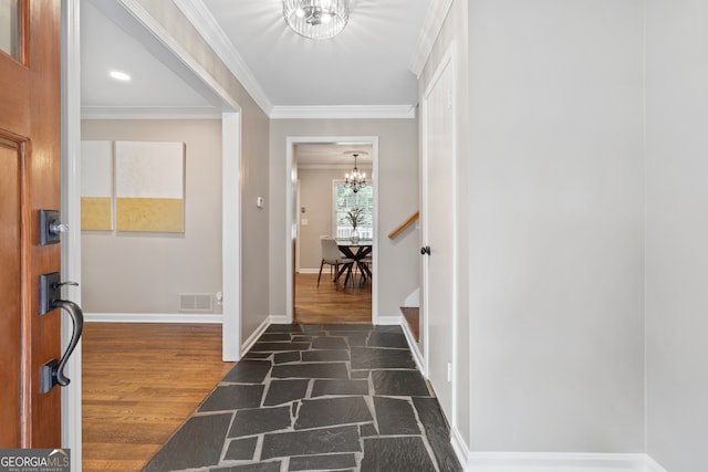 foyer featuring crown molding, dark wood-type flooring, and a chandelier