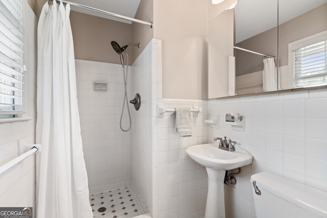 bathroom with tile walls, a shower with curtain, toilet, and backsplash