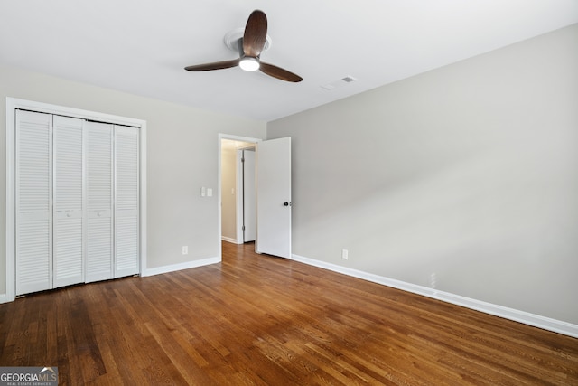 unfurnished bedroom with wood-type flooring, ceiling fan, and a closet