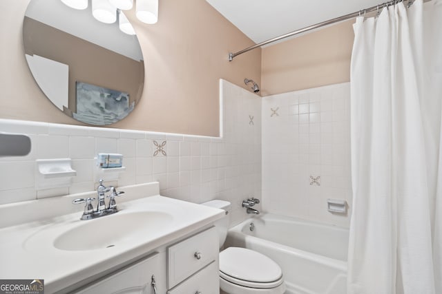 full bathroom with toilet, vanity, backsplash, shower / bath combo with shower curtain, and tile walls