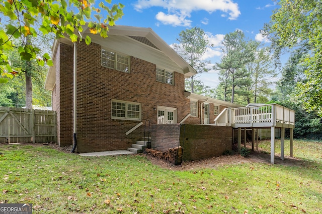 back of property featuring a wooden deck and a yard