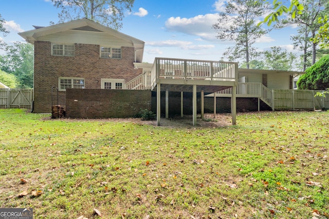 rear view of house featuring a wooden deck and a lawn