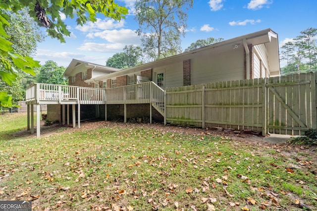 back of house with a wooden deck and a yard