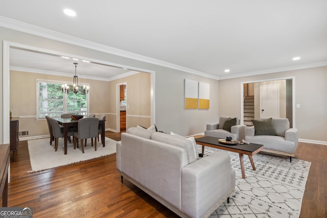 living room featuring ornamental molding, hardwood / wood-style floors, and an inviting chandelier