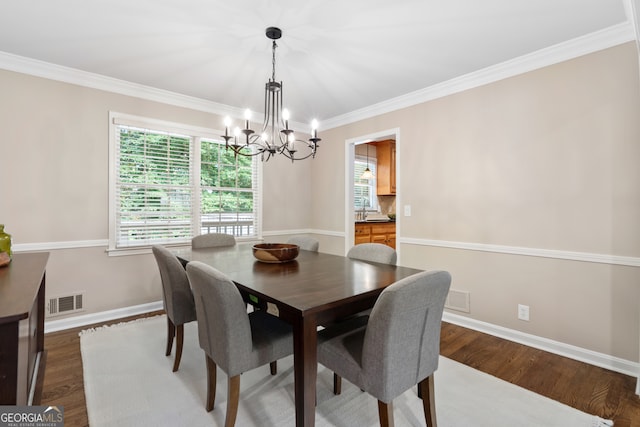 dining room with an inviting chandelier, dark hardwood / wood-style flooring, and ornamental molding