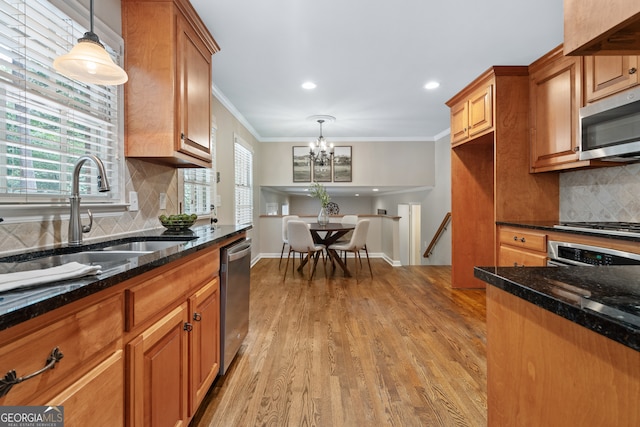 kitchen featuring an inviting chandelier, light hardwood / wood-style flooring, stainless steel appliances, sink, and pendant lighting