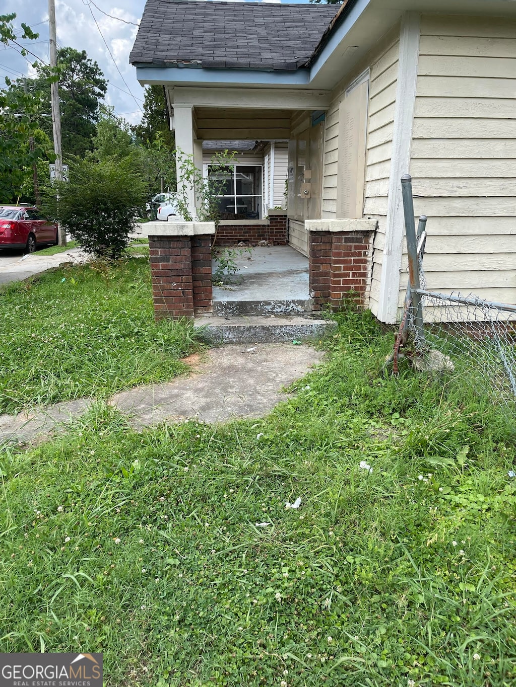 property entrance featuring a porch and a yard