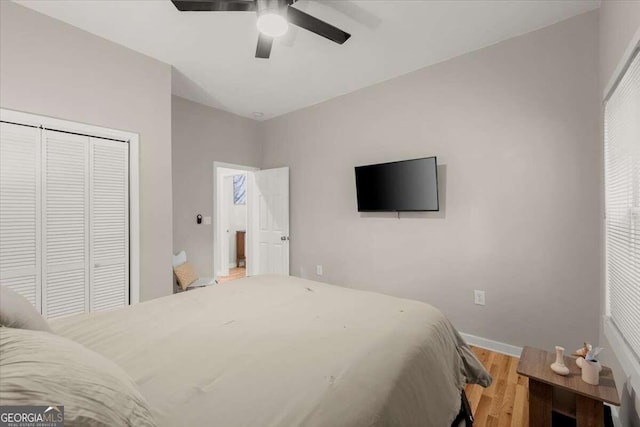 bedroom featuring hardwood / wood-style floors, ceiling fan, and a closet