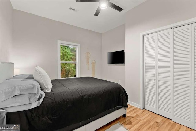 bedroom with a closet, ceiling fan, and light hardwood / wood-style flooring