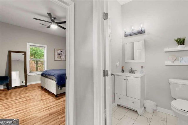 bathroom with vanity, toilet, hardwood / wood-style floors, and ceiling fan