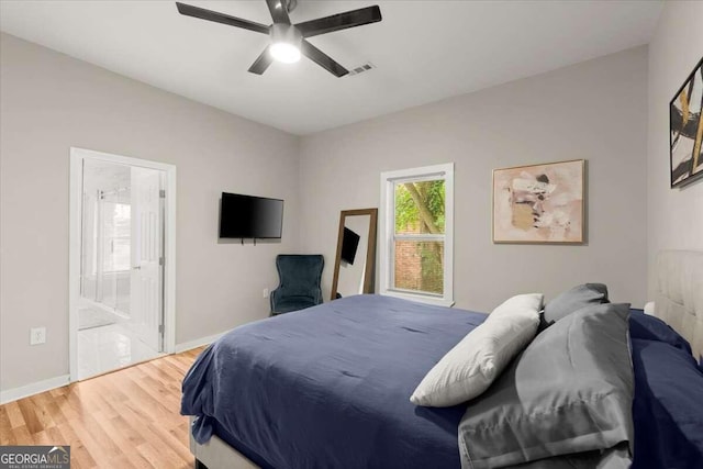 bedroom with hardwood / wood-style floors, ceiling fan, and connected bathroom