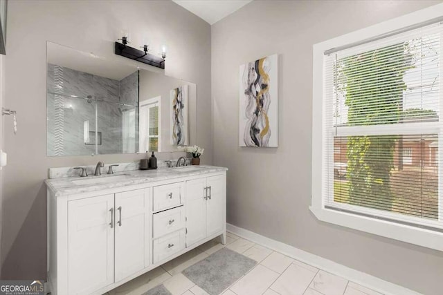 bathroom with a shower with door, vanity, and a wealth of natural light