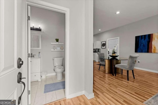 bathroom featuring toilet, hardwood / wood-style floors, and sink