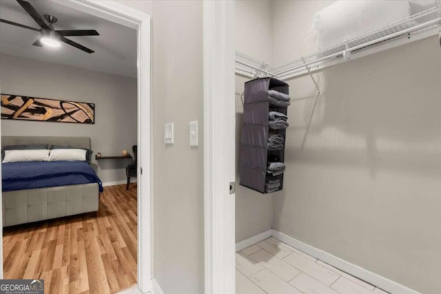 walk in closet with ceiling fan and light hardwood / wood-style flooring