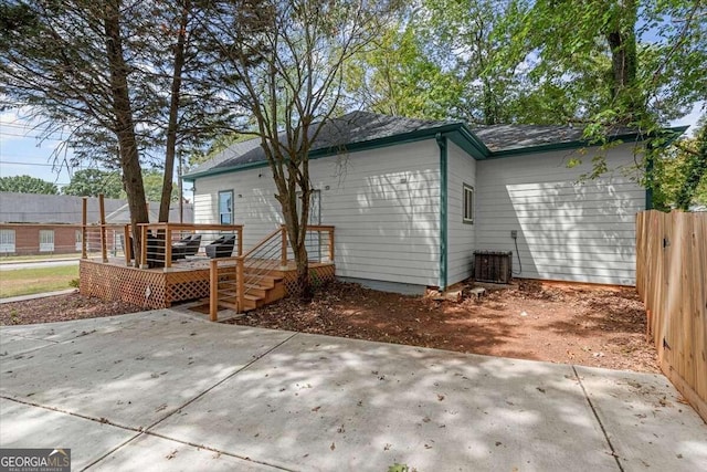 rear view of house featuring a wooden deck, a patio area, and central air condition unit