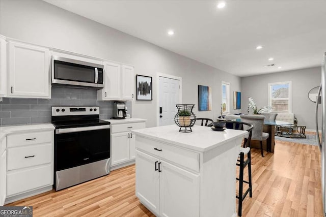 kitchen featuring light wood-type flooring, appliances with stainless steel finishes, and white cabinets