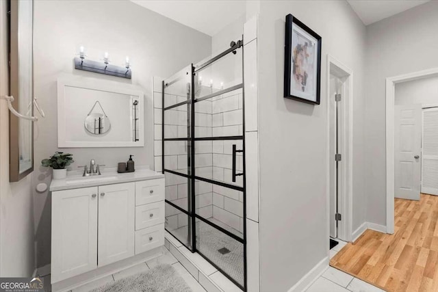 bathroom featuring wood-type flooring, an enclosed shower, and vanity