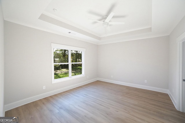 spare room with hardwood / wood-style flooring, ceiling fan, and a tray ceiling