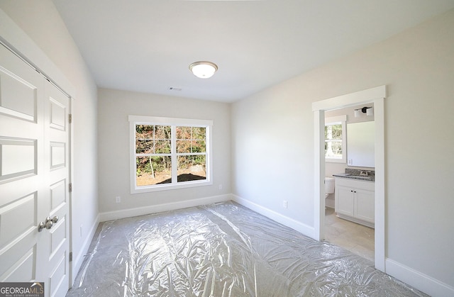 unfurnished bedroom featuring sink and connected bathroom