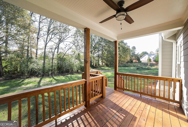 wooden terrace featuring ceiling fan and a yard