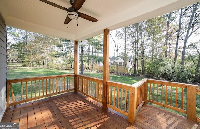 wooden deck featuring a lawn and ceiling fan