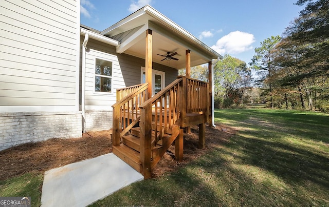 wooden terrace with ceiling fan and a yard