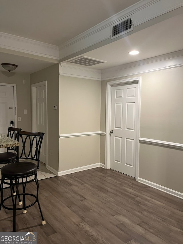 dining space with ornamental molding and dark hardwood / wood-style flooring