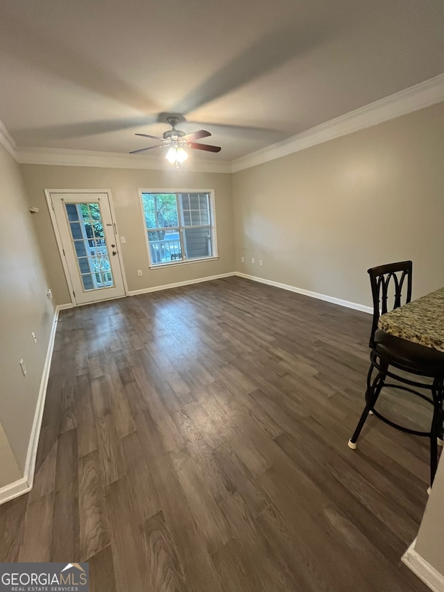 unfurnished living room featuring crown molding, ceiling fan, and dark hardwood / wood-style floors