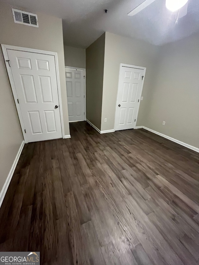 empty room with dark wood-type flooring and ceiling fan