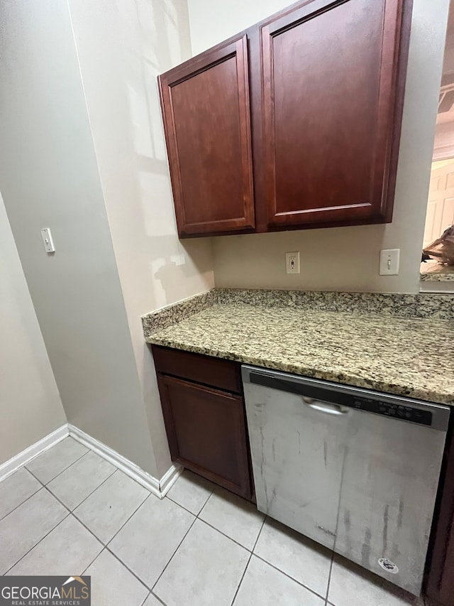 kitchen with light tile patterned floors, light stone countertops, and dishwasher