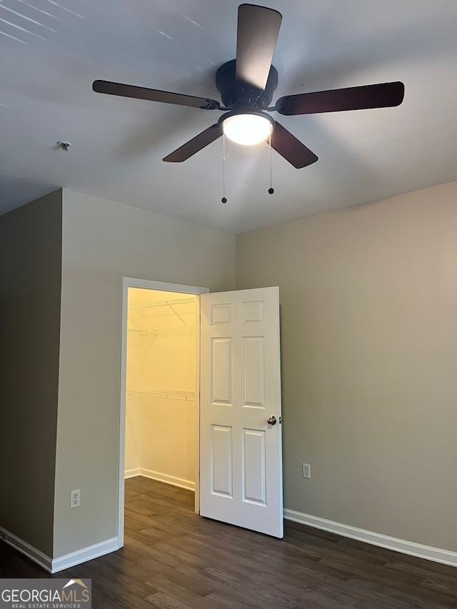 empty room with dark wood-type flooring and ceiling fan