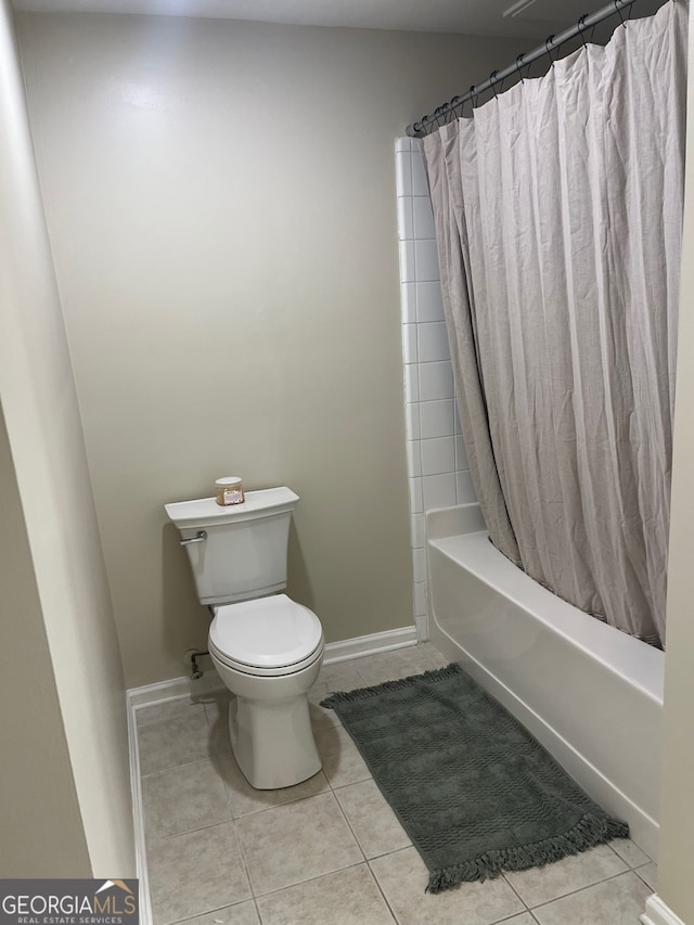 bathroom featuring toilet, shower / tub combo with curtain, and tile patterned floors