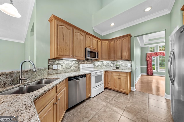 kitchen with light stone counters, pendant lighting, appliances with stainless steel finishes, and sink