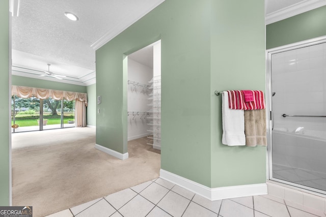 bathroom featuring ceiling fan, a textured ceiling, ornamental molding, and tile patterned floors