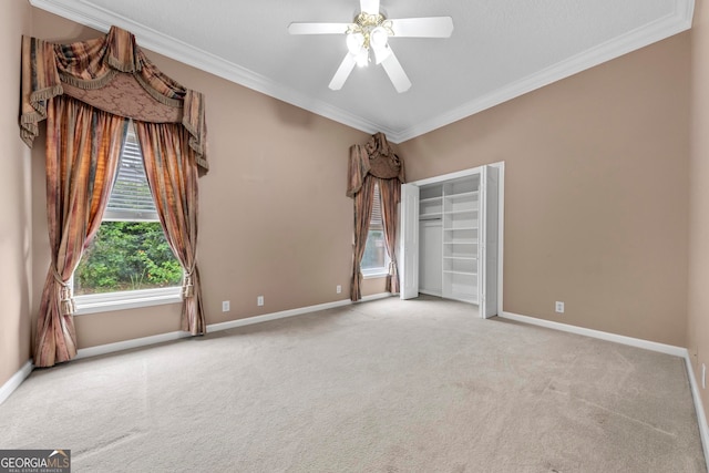 unfurnished room with ceiling fan, light colored carpet, and ornamental molding