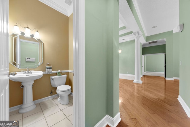 bathroom with hardwood / wood-style floors, ornamental molding, toilet, and ornate columns