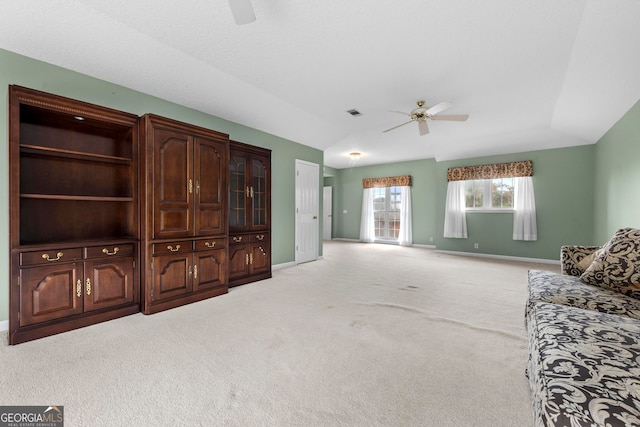 living room with lofted ceiling, ceiling fan, and carpet flooring