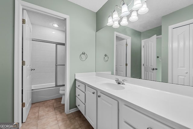 full bathroom featuring shower / bath combination with glass door, vanity, a textured ceiling, tile patterned floors, and toilet