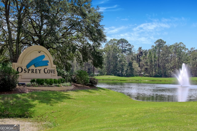 view of home's community with a water view and a yard