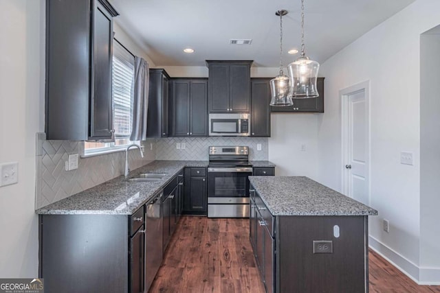 kitchen with a center island, appliances with stainless steel finishes, sink, and dark wood-type flooring