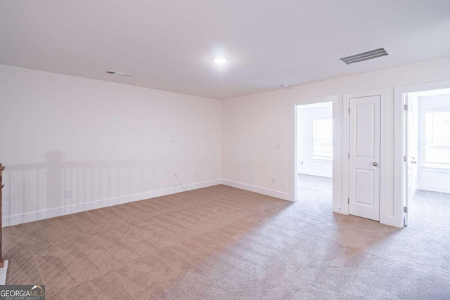 unfurnished room featuring light carpet