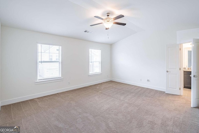 empty room featuring plenty of natural light, ceiling fan, and light colored carpet