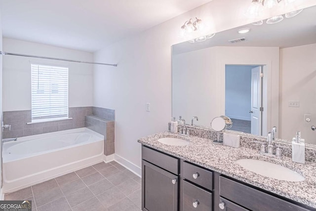 bathroom with tile patterned floors, a bathtub, and vanity