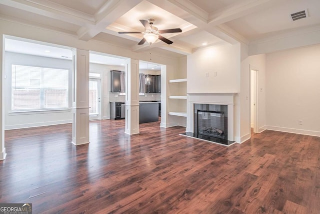 unfurnished living room featuring a tiled fireplace, coffered ceiling, dark hardwood / wood-style floors, ceiling fan, and beam ceiling