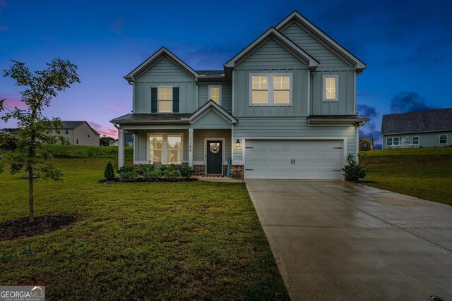 view of front of property featuring covered porch, a garage, and a front lawn