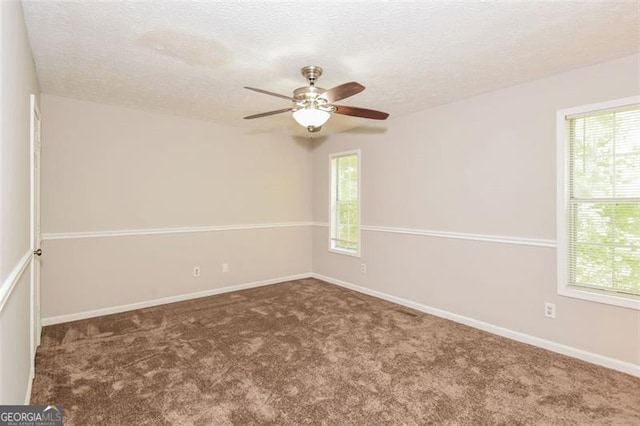 unfurnished room with a textured ceiling, ceiling fan, and carpet flooring