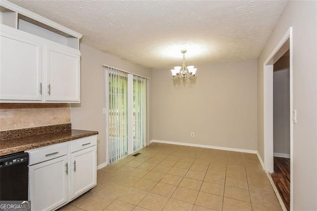 kitchen with a textured ceiling, hanging light fixtures, an inviting chandelier, and white cabinetry