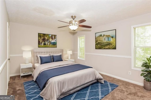 bedroom featuring multiple windows, a textured ceiling, ceiling fan, and carpet