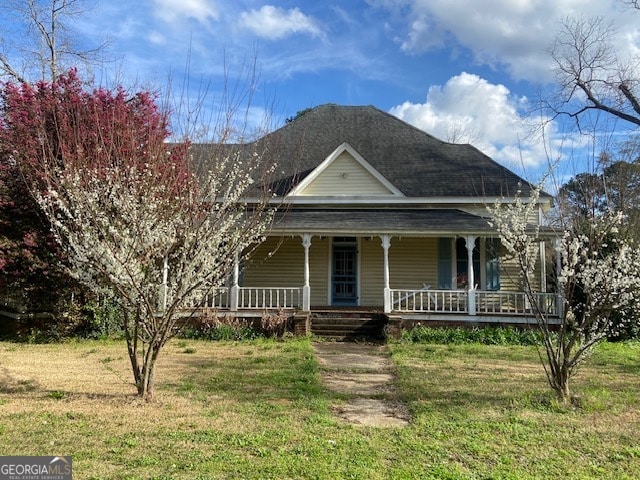 farmhouse inspired home featuring a front lawn and a porch