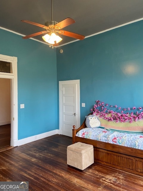 bedroom featuring dark wood-type flooring, ceiling fan, and ornamental molding